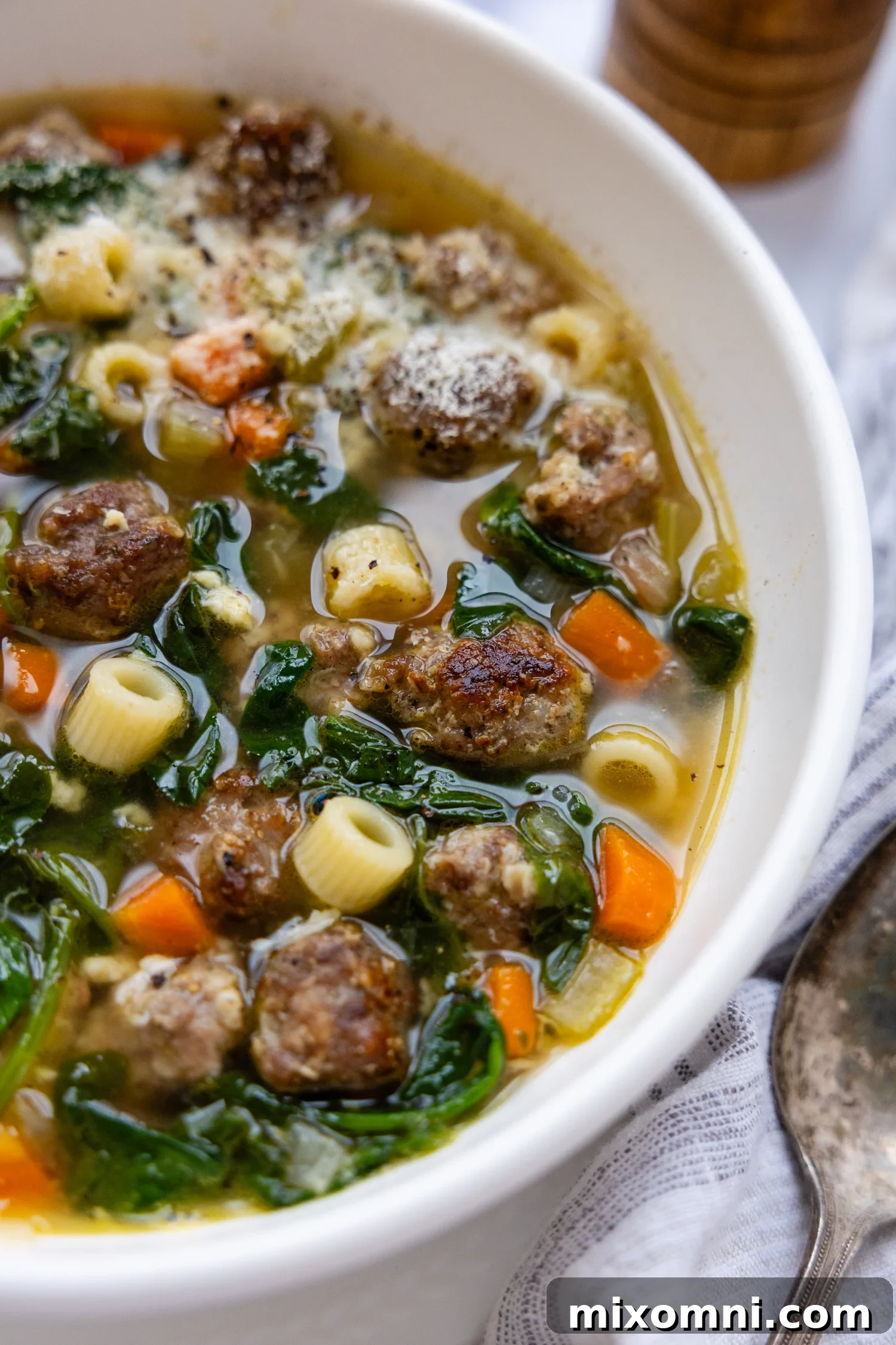 Gluten Free Italian Wedding Soup in a white bowl, garnished with fresh parsley.