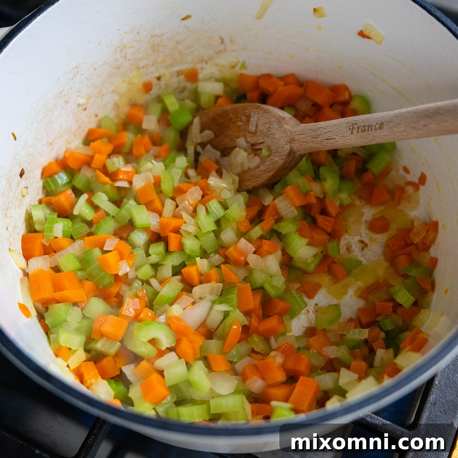 Diced carrots, celery, and onion sautéing in a stock pot.