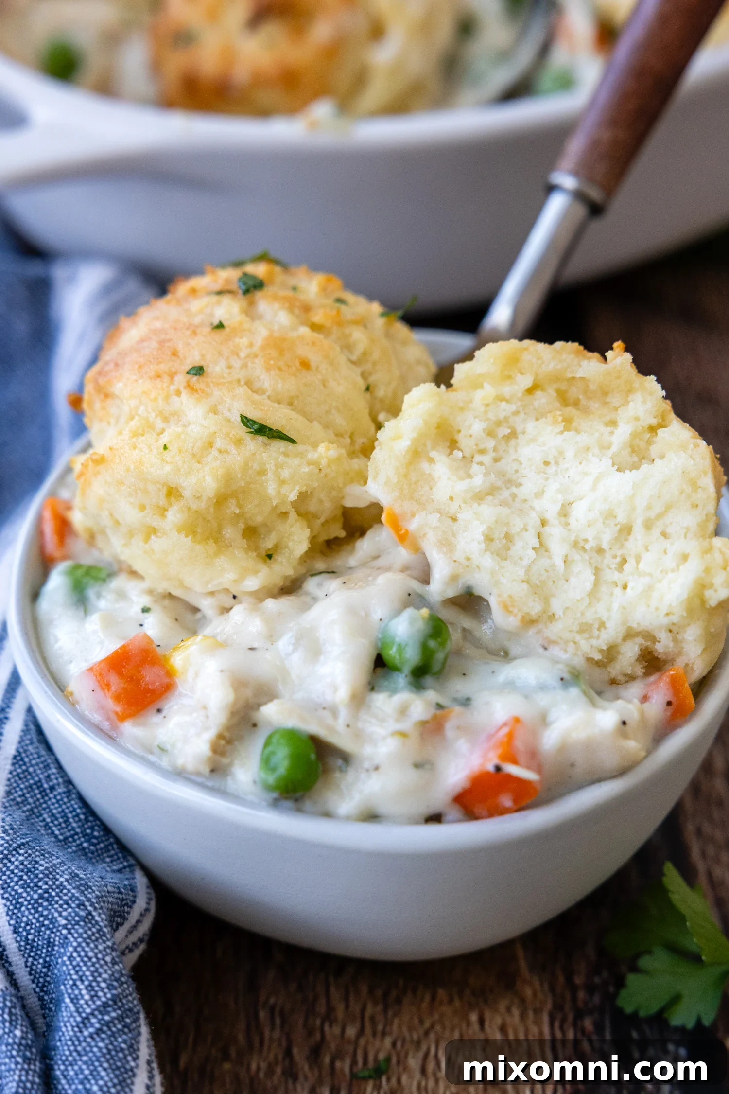 Gluten-Free Chicken and Biscuits served in a white bowl and one of the biscuits is opened to show the inside texture.