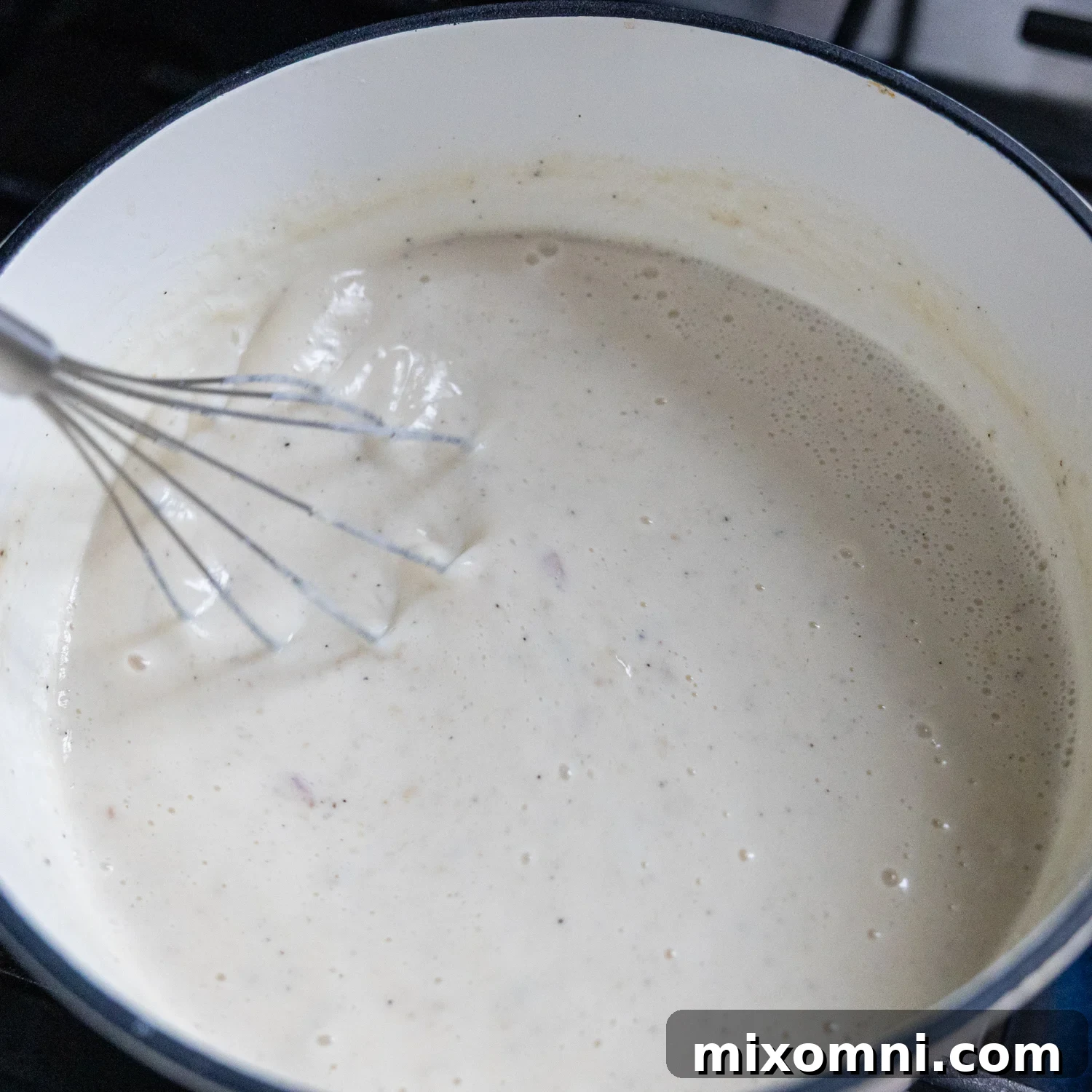 Broth being whisked into flour mixture.