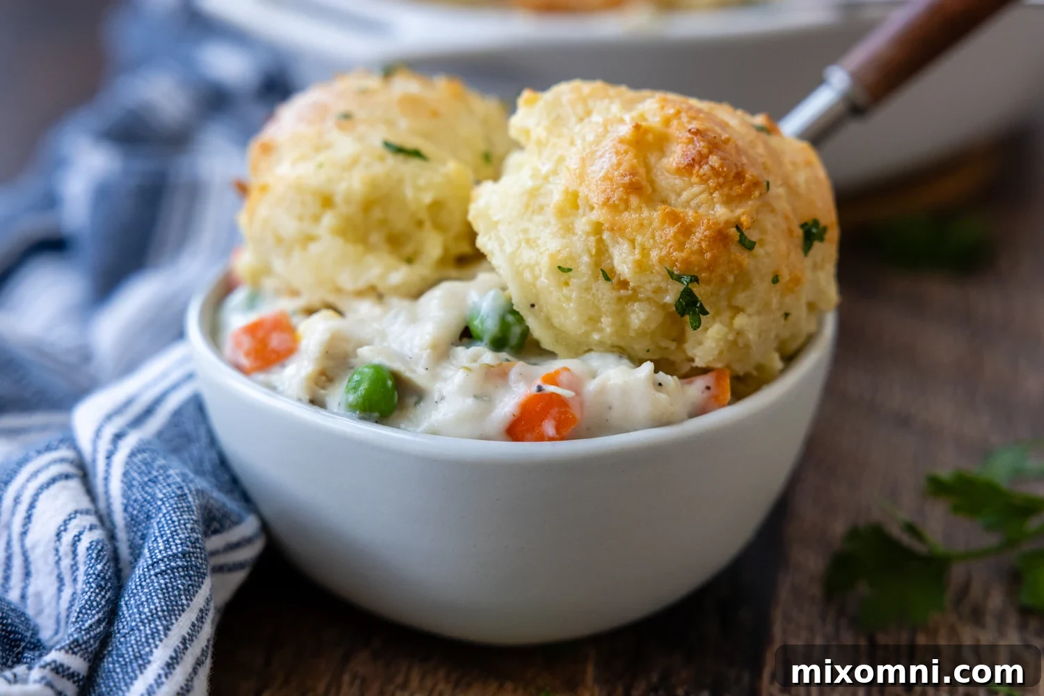 White bowl of chicken and biscuits.