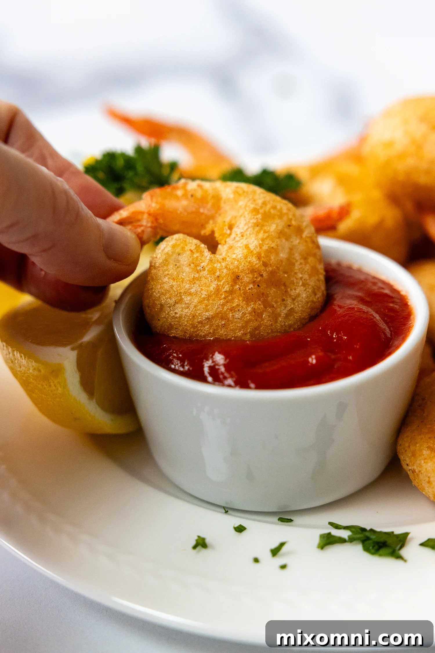 Golden-brown, crispy gluten-free fried shrimp served on a white plate, ready to be enjoyed.
