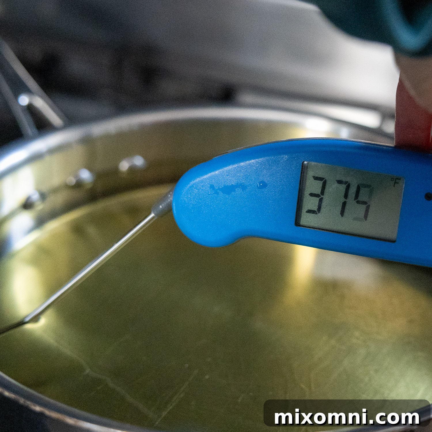 A thermometer accurately testing the oil temperature in a deep skillet.