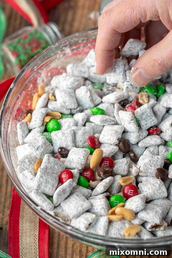 A hand scooping up some Nutella reindeer puppy chow, decorated for Christmas.
