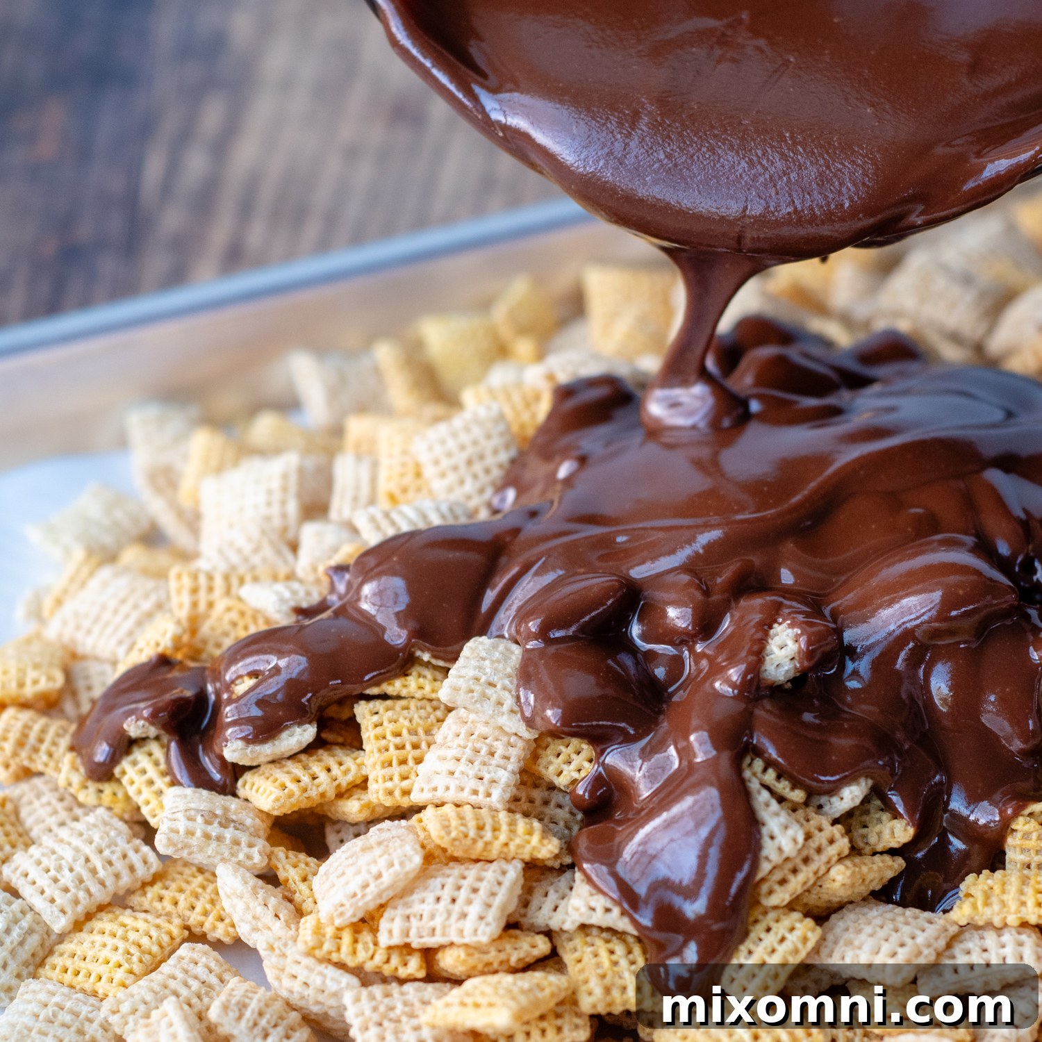 Melted Nutella poured over Chex cereal, ready for mixing.