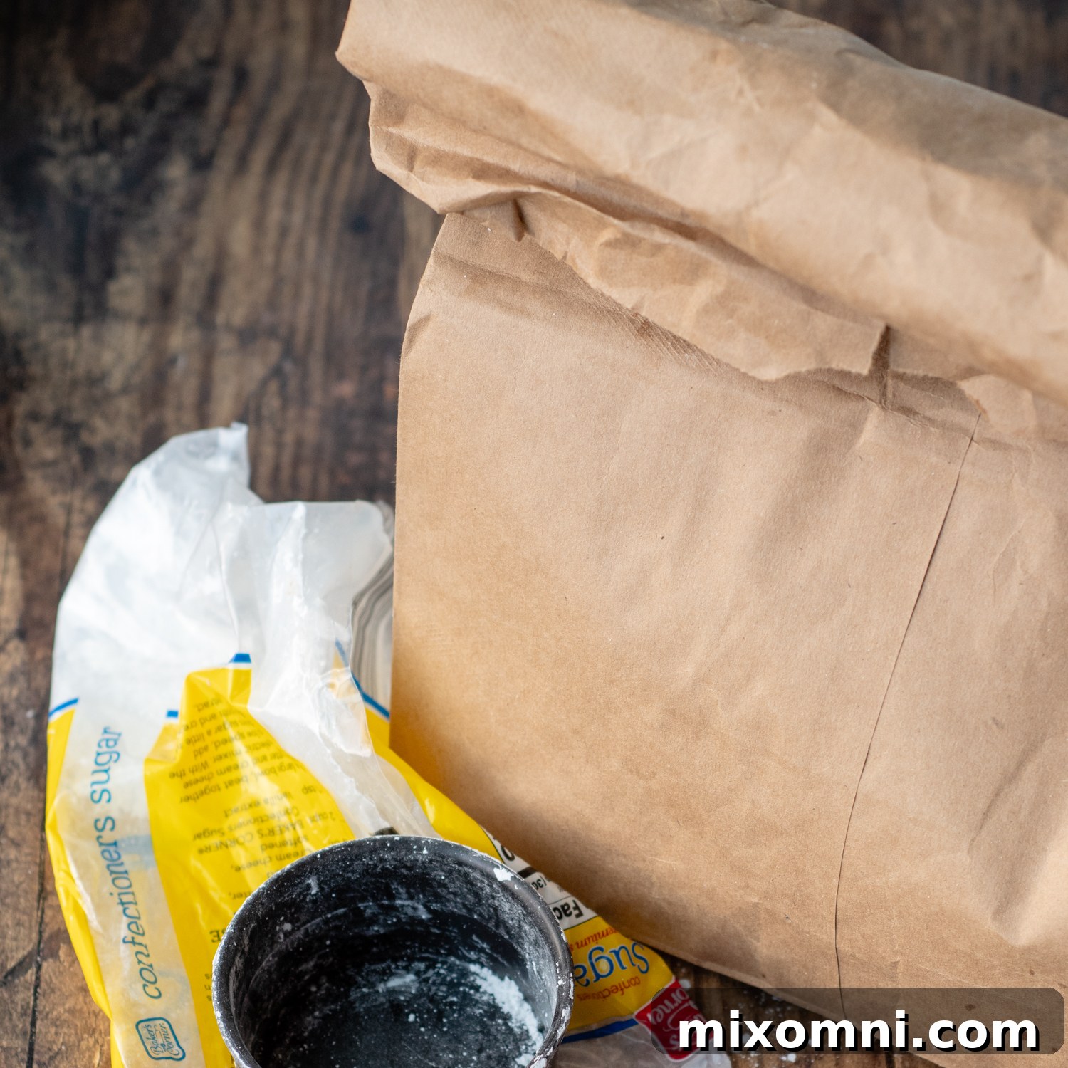 A paper bag containing puppy chow, with powdered sugar ready to be added for the second shake.