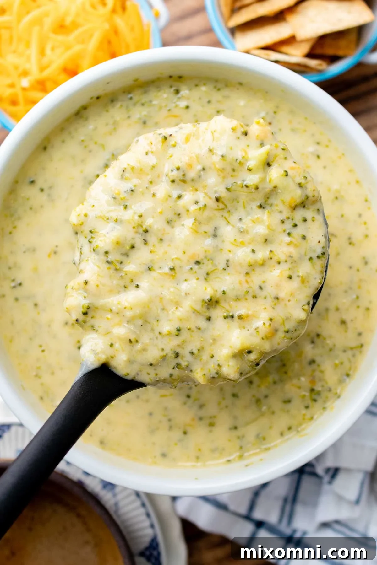overhead shot of a ladle holding up thick and creamy Instant Pot broccoli cheese soup