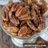 An overhead shot of candied pecans in an antique silver bowl
