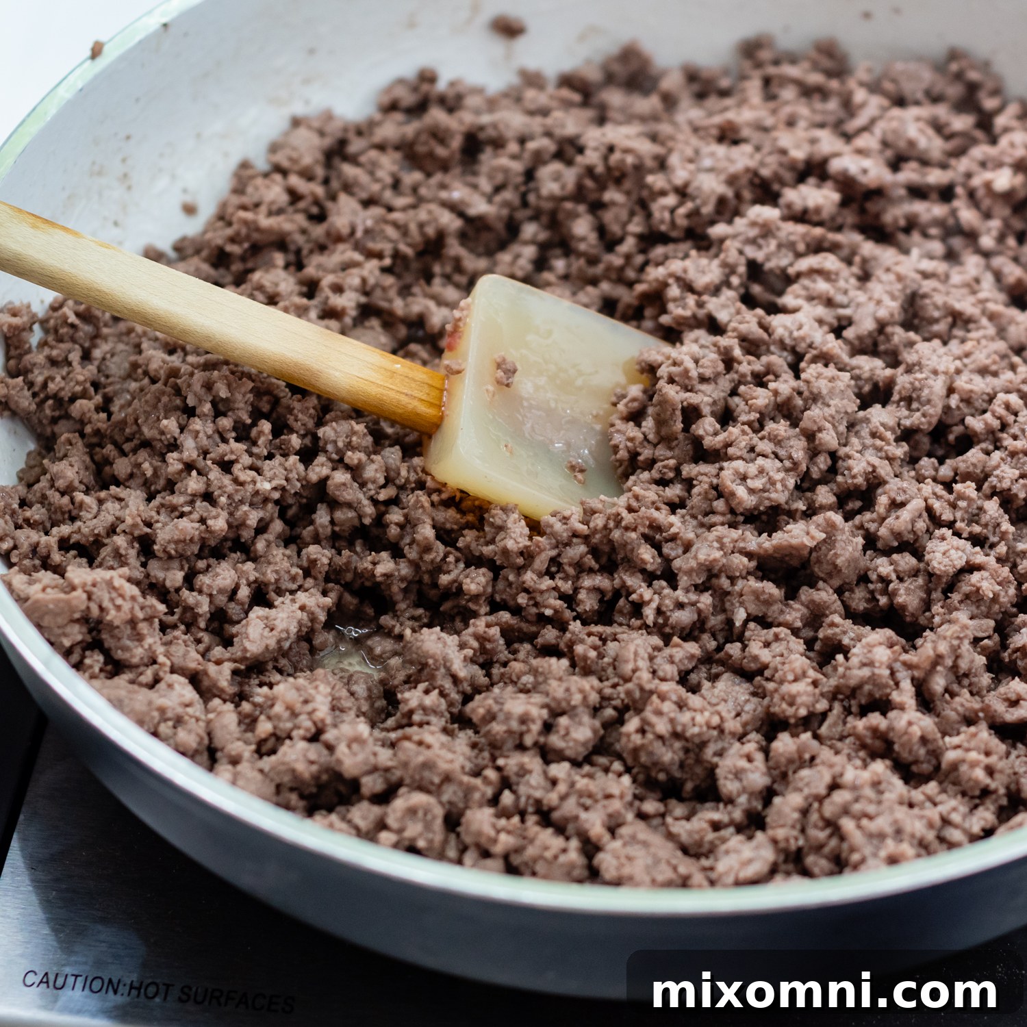 Close-up of perfectly browned ground beef sizzling in a skillet, ready for the next step.