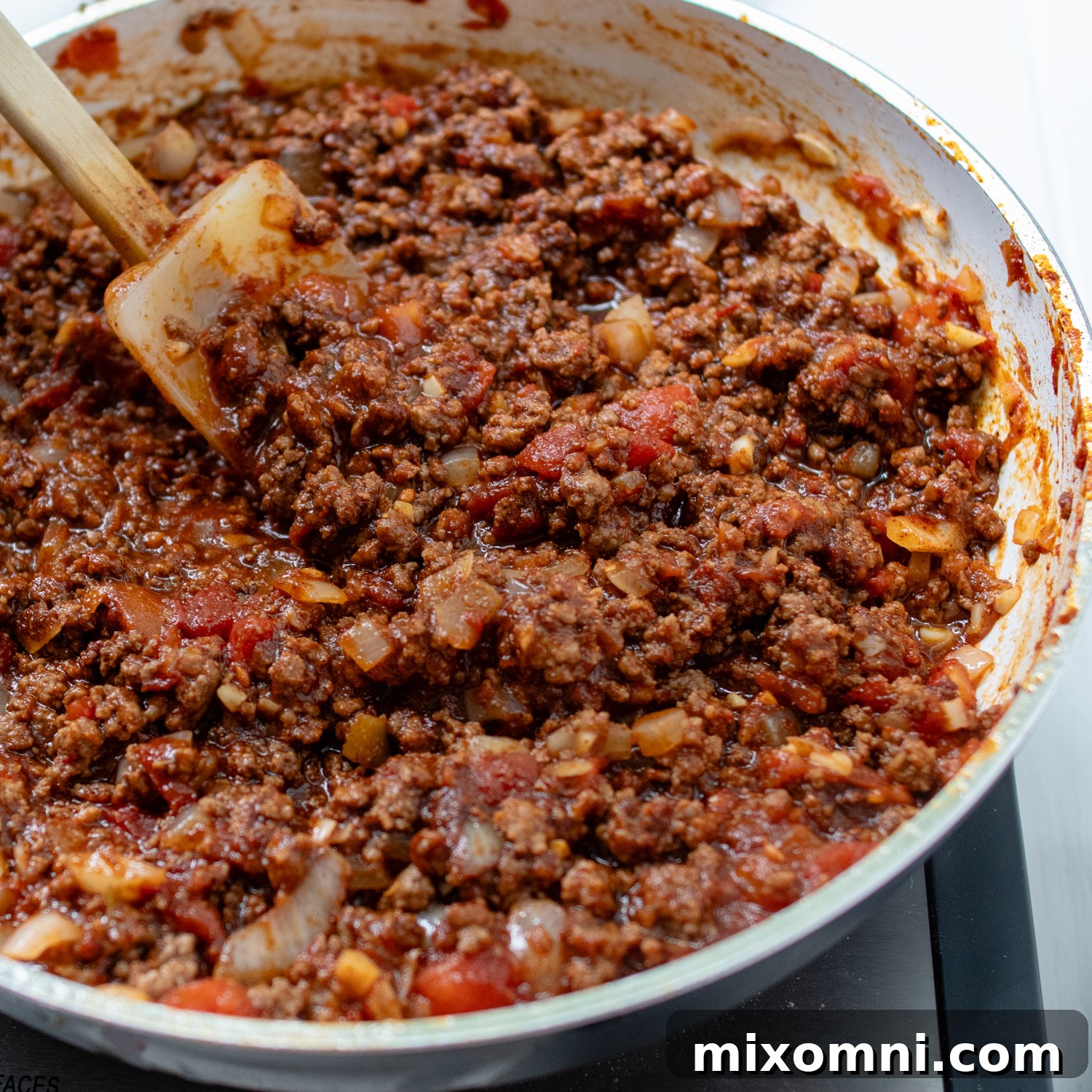 The seasoned taco meat simmering in a skillet, coated in a rich sloppy joe-style sauce, ready for its final bake.