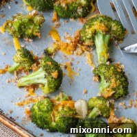 A close up shot overhead of baked broccoli and cheese on a baking sheet