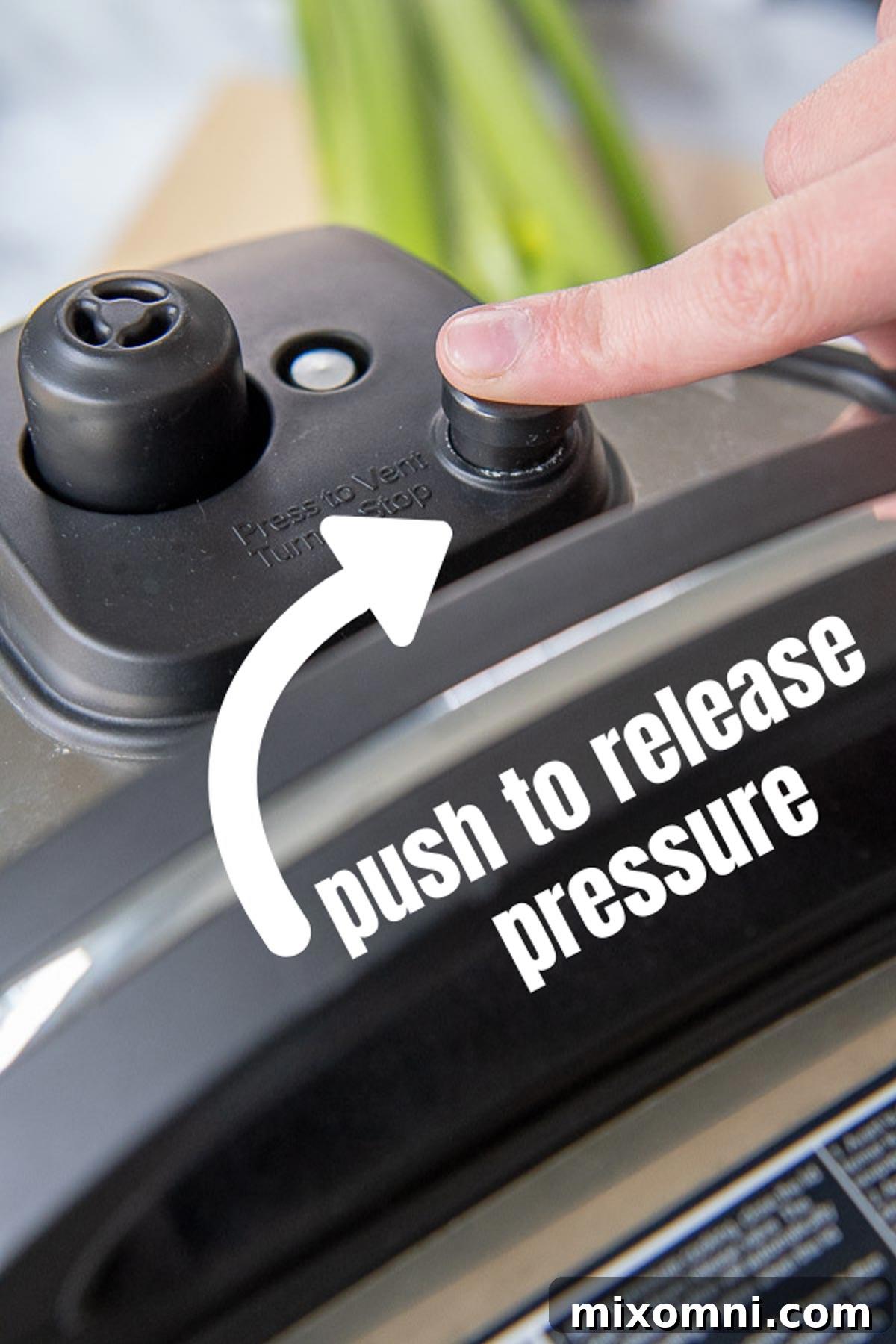 a finger pushing a pressure cooker seal valve