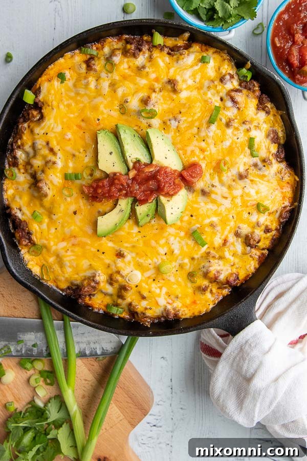 An overhead view of a hearty Tamale Pie in a cast iron skillet, ready to be served.