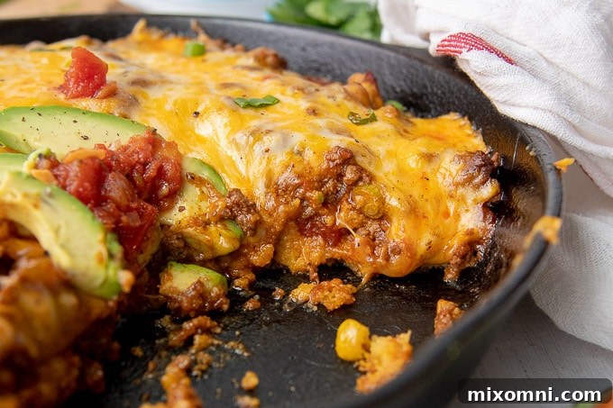 A close-up side view of a perfectly sliced Tamale Pie, showing distinct layers of cornbread, beef, and cheese.