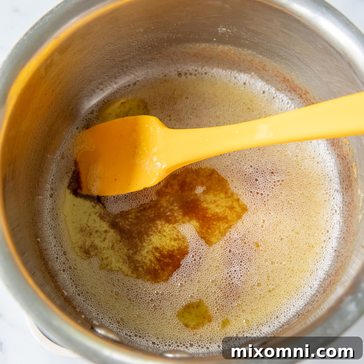 A small saucepan with beautifully melted and browned butter, showing the golden milk solids at the bottom.