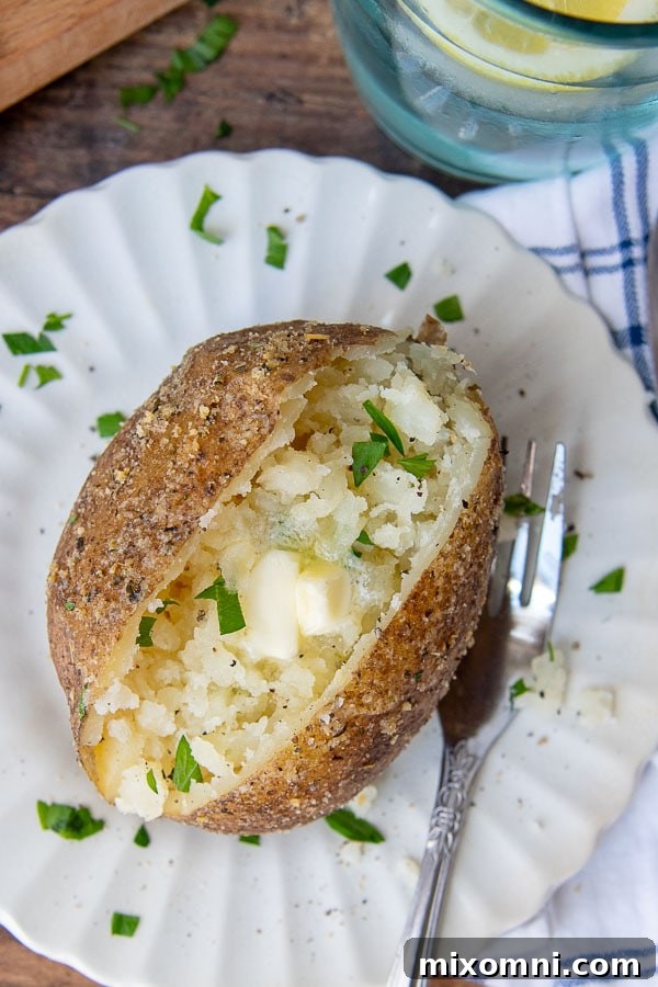 An overhead shot of an Instant Pot baked potato split open with melting butter in the middle.