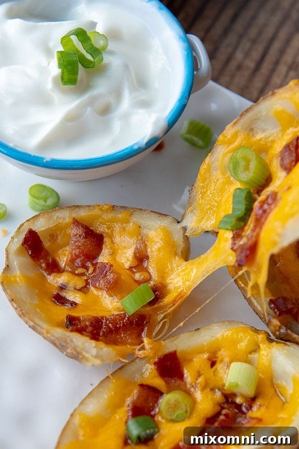 a cheesy potato skin being pulled apart on a white plate