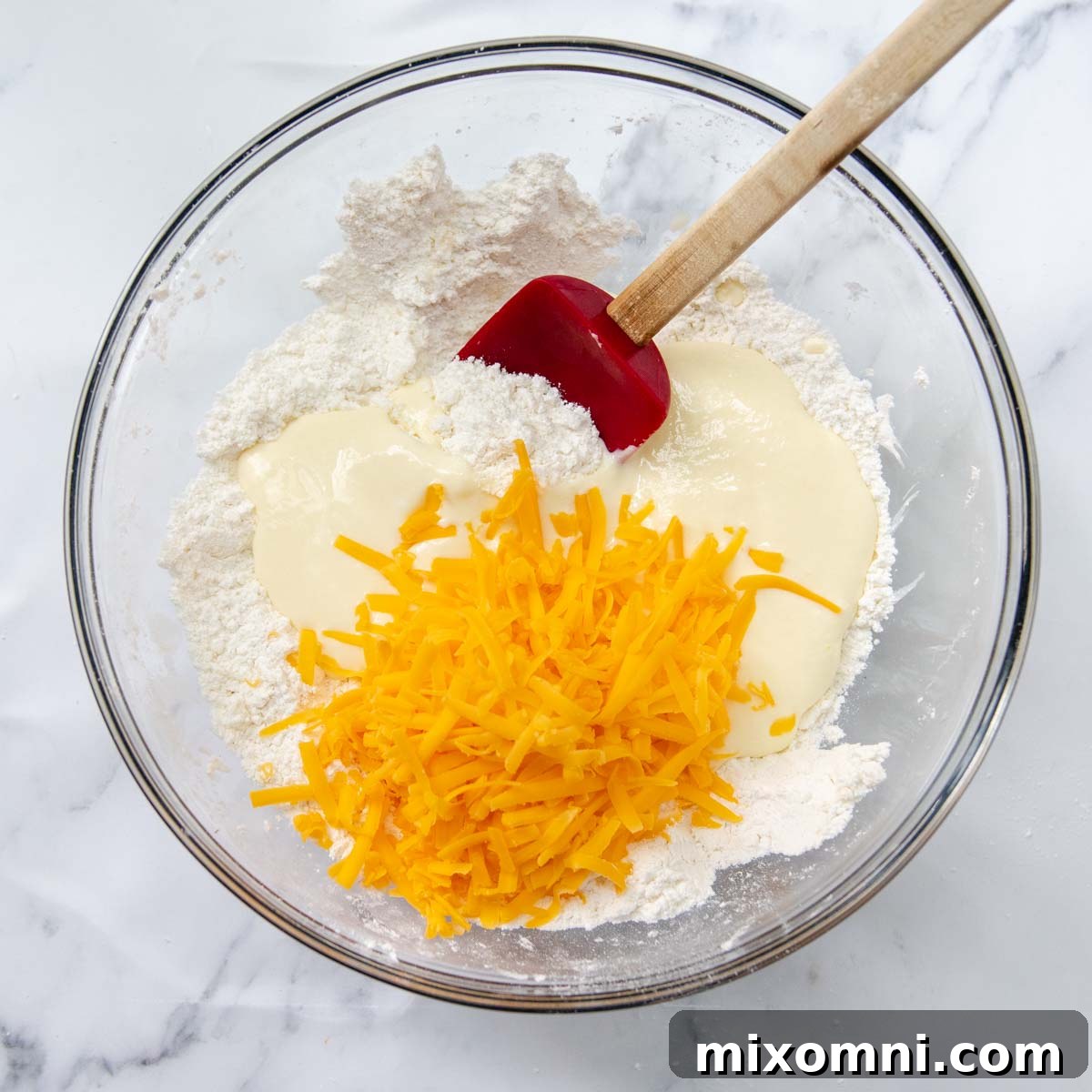 Yogurt and cheese mixture being stirred into the flour and butter mixture to form a soft dough.