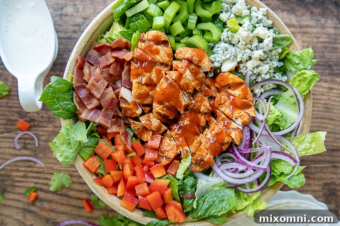 an overhead shot of a large salad bowl containing an assembled buffalo chicken salad, ready to be enjoyed