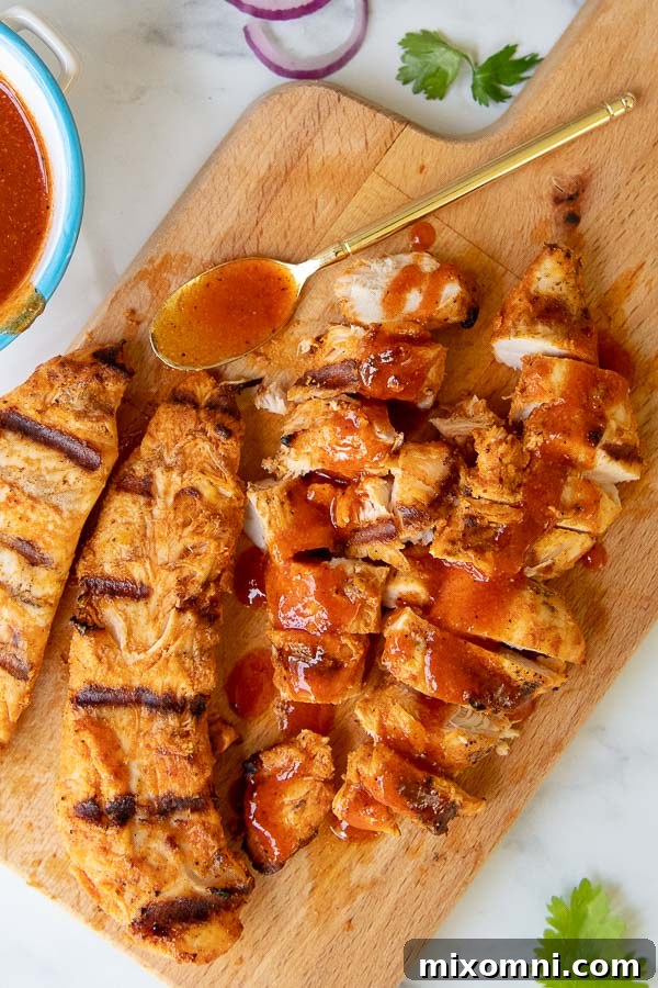 chopped grilled buffalo chicken on a wooden cutting board, ready for the salad