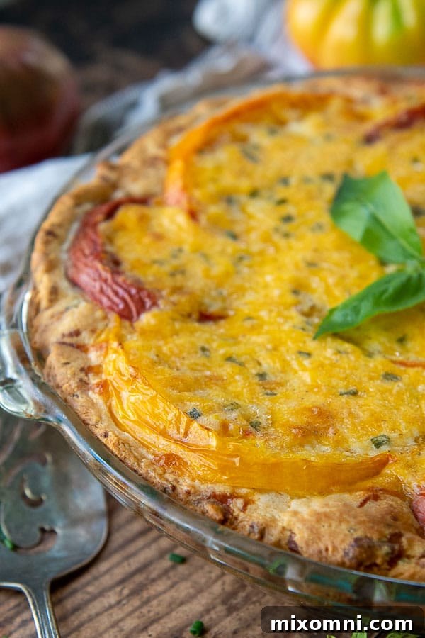 A close-up shot of the tomato pie crust, showcasing the layers of sliced tomatoes and cheesy topping before baking.