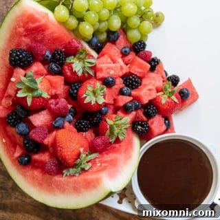 Close up of watermelon on dessert board with a cup of chocolate next to it