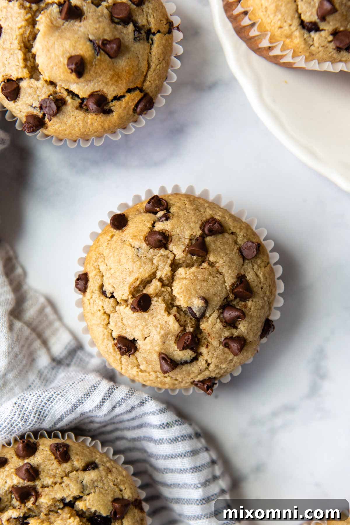 overhead shot of almond flour muffins on a white marble surface with a gray linen.