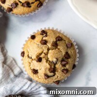 overhead shot of almond flour muffins on a white marble surface with a gray linen.