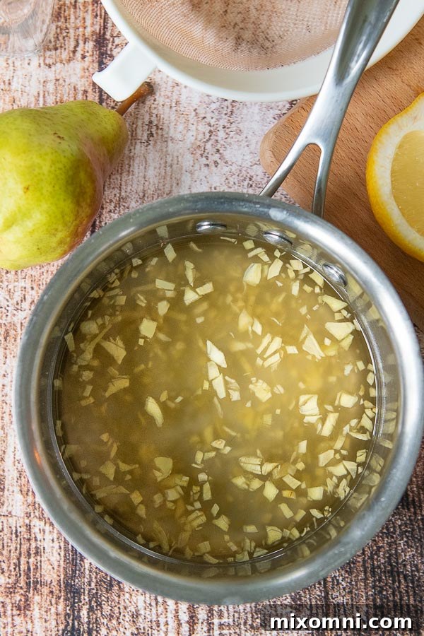 a pan of ginger syrup with fresh chopped ginger inside