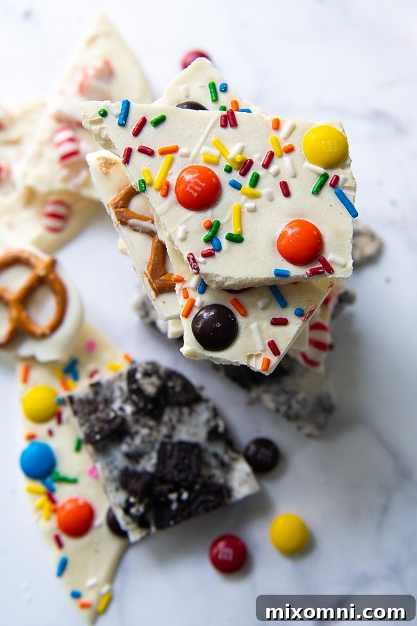 An overhead view capturing the diverse appeal of various white chocolate bark styles, including Oreo, peppermint, pretzel, and Christmas-themed bark, arranged for a delightful display.
