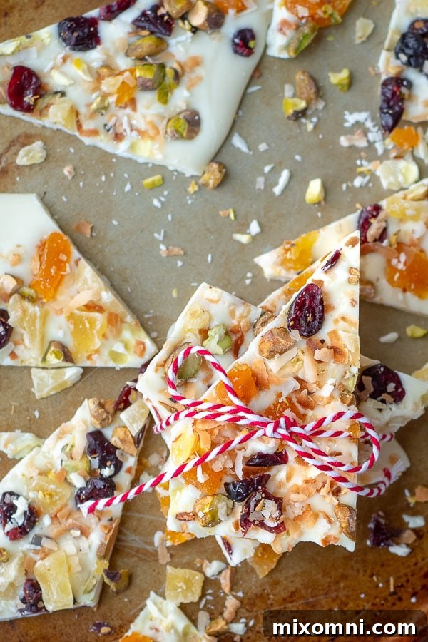 A beautiful piece of white chocolate fruit and nut bark, tied with string, displayed on a baking sheet, highlighting its rustic and inviting homemade charm.