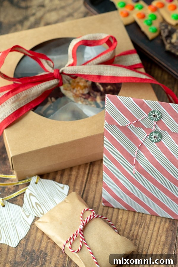 A person demonstrating how to wrap white chocolate bark as a gift, using clear cellophane bags, colorful ribbons, and decorative tags for a personalized touch.