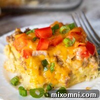 A slice of breakfast casserole on a white plate with green onions.