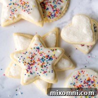 cut out cookies with white frosting and sprinkles