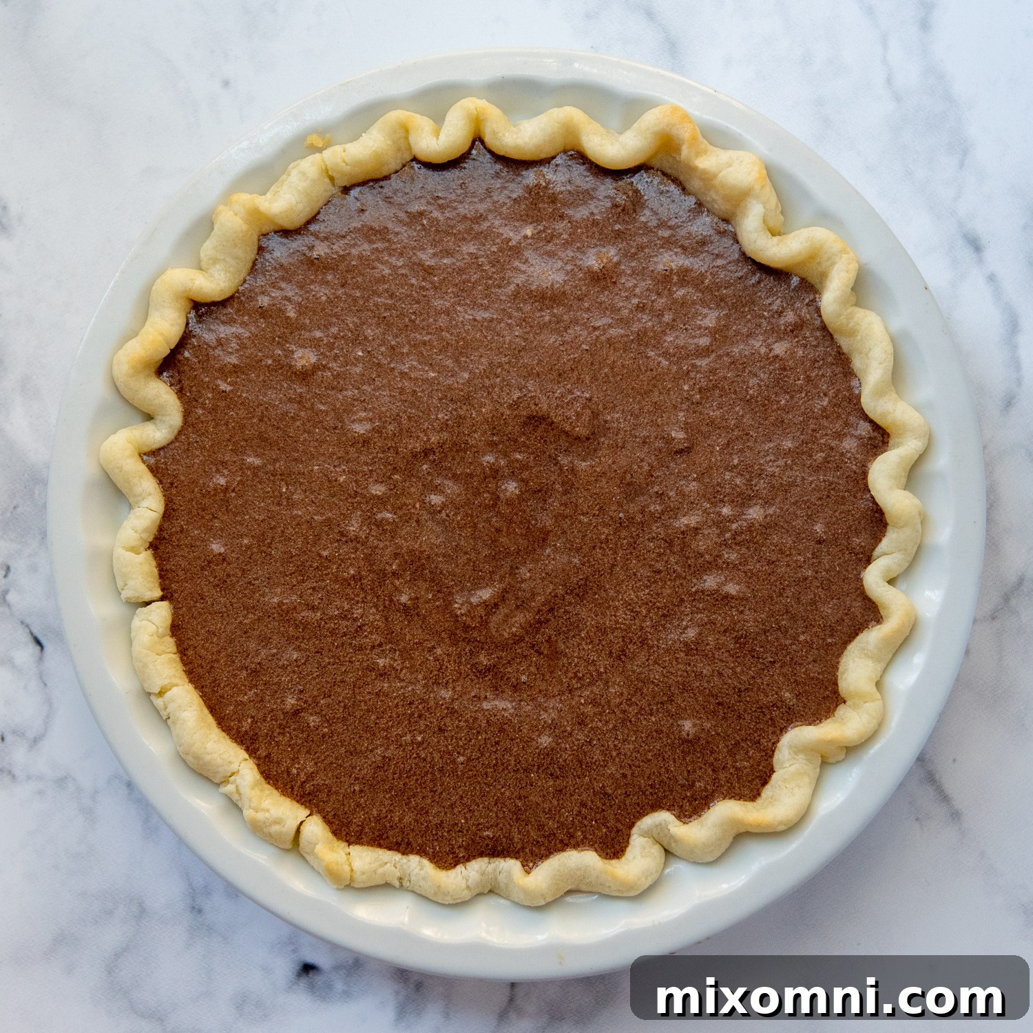 The perfectly baked chocolate chess pie, with its beautiful cracked top, cooling on a wire rack.