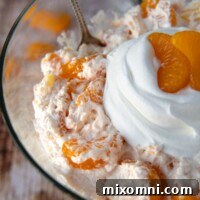 Close up of the top of orange fluff with whipped cream on top, ready for serving.
