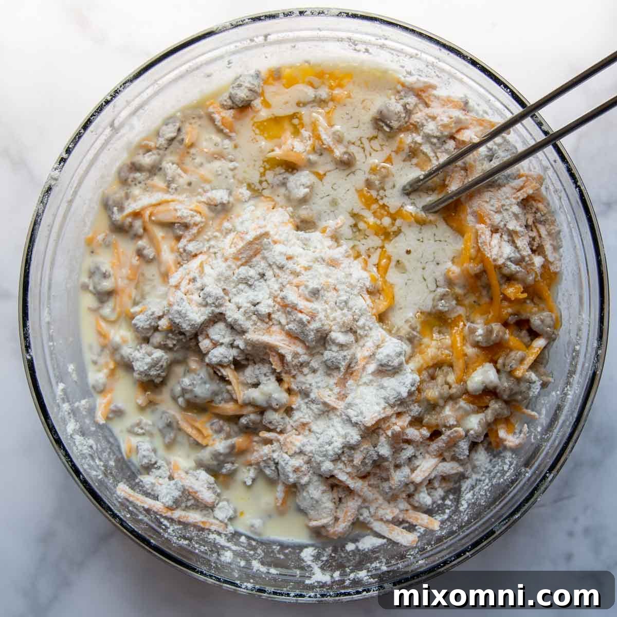 Muffin batter in a mixing bowl with wet ingredients freshly stirred in, showing a slightly lumpy but well-combined mixture.