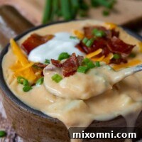 A close-up of a spoon lifting out a spoonful of instant pot potato soup