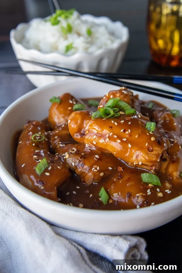 side angle shot of asian chicken thighs with chopsticks resting on side