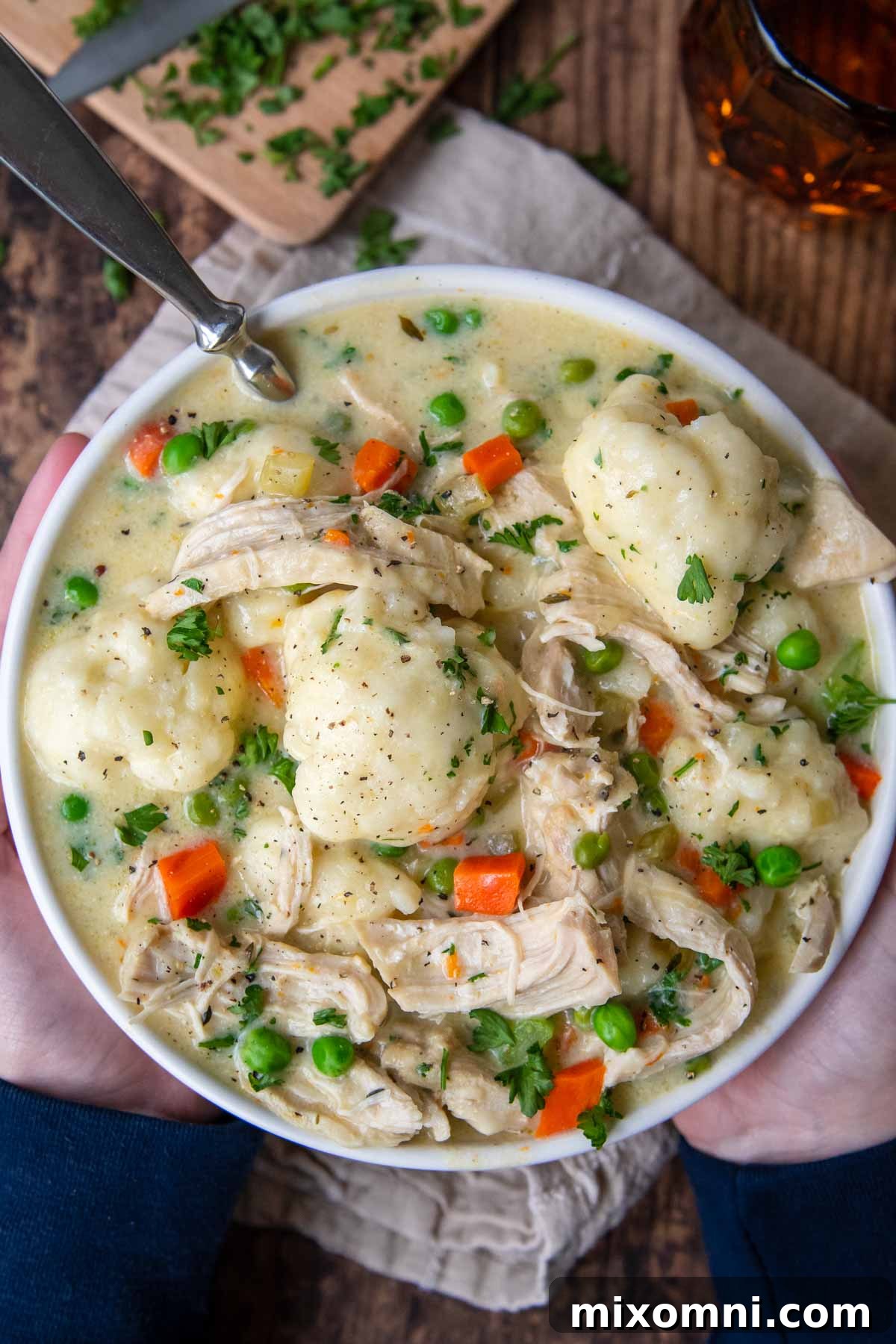 An overhead shot of a white bowl filled with creamy Instant Pot gluten-free chicken and dumplings, ready to be enjoyed.