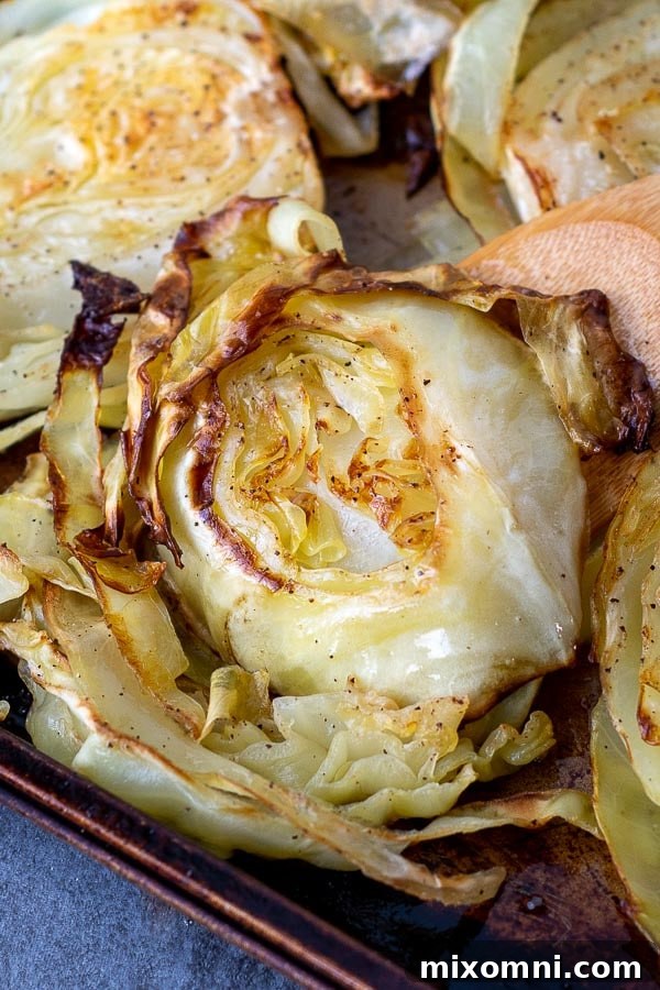 a close up of golden, crispy roasted cabbage on a baking sheet, ready to serve