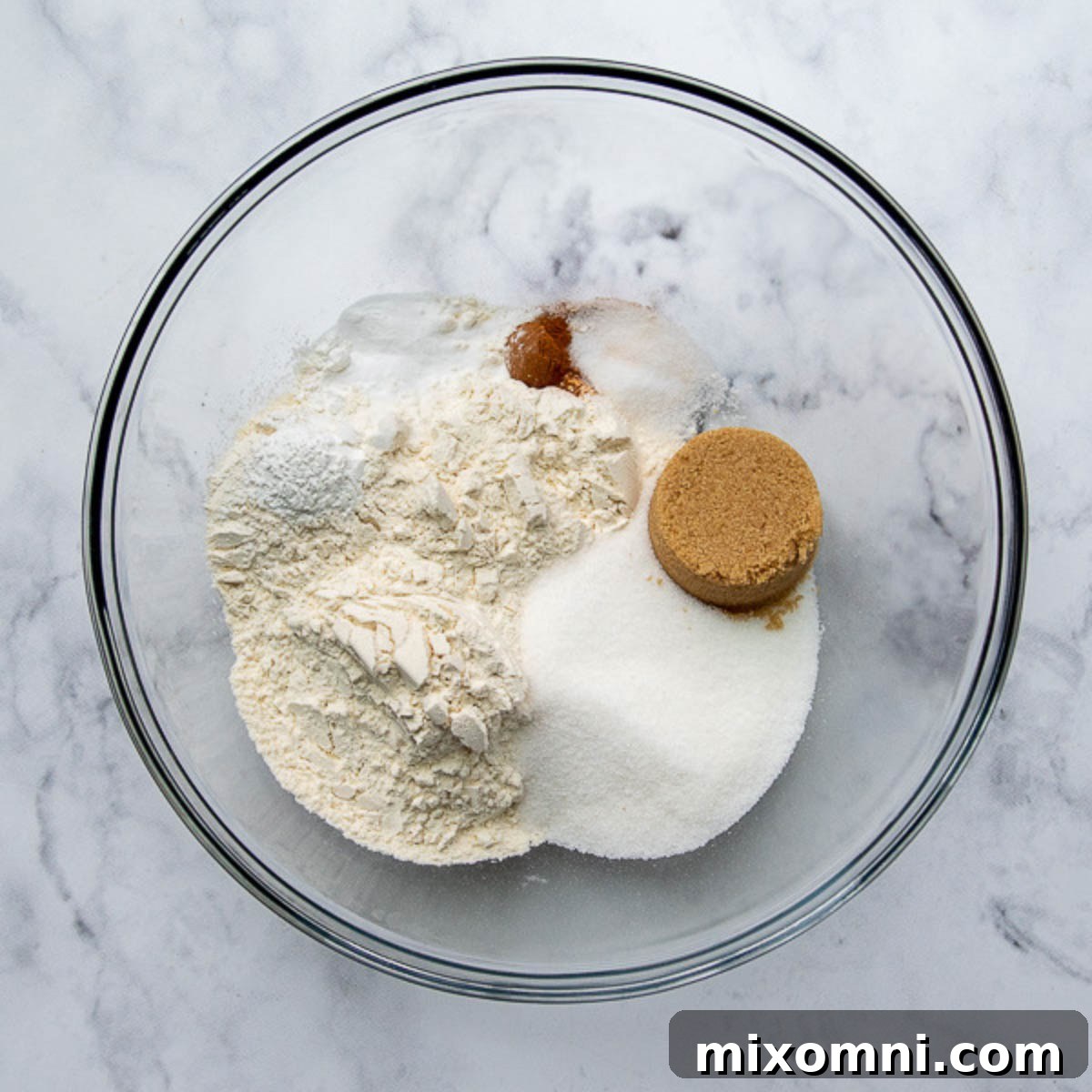 A glass bowl filled with whisked dry ingredients for muffins.