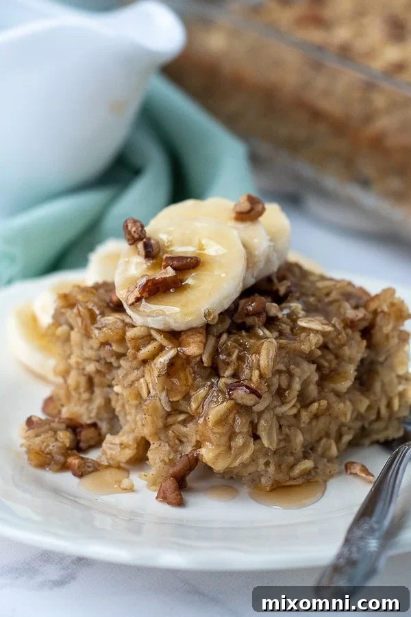 A golden-brown slice of banana baked oatmeal, drizzled with glistening pure maple syrup.