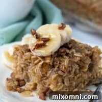 A slice of banana baked oatmeal with maple syrup dripping off