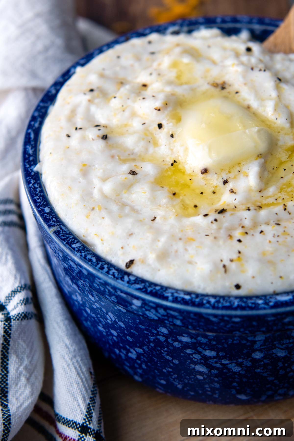 A beautifully plated bowl of creamy grits, topped with melted butter and freshly cracked black pepper, ready to be enjoyed.