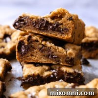 Stack of chocolate chip cookies bars show the cross section and internal melted chocolate.