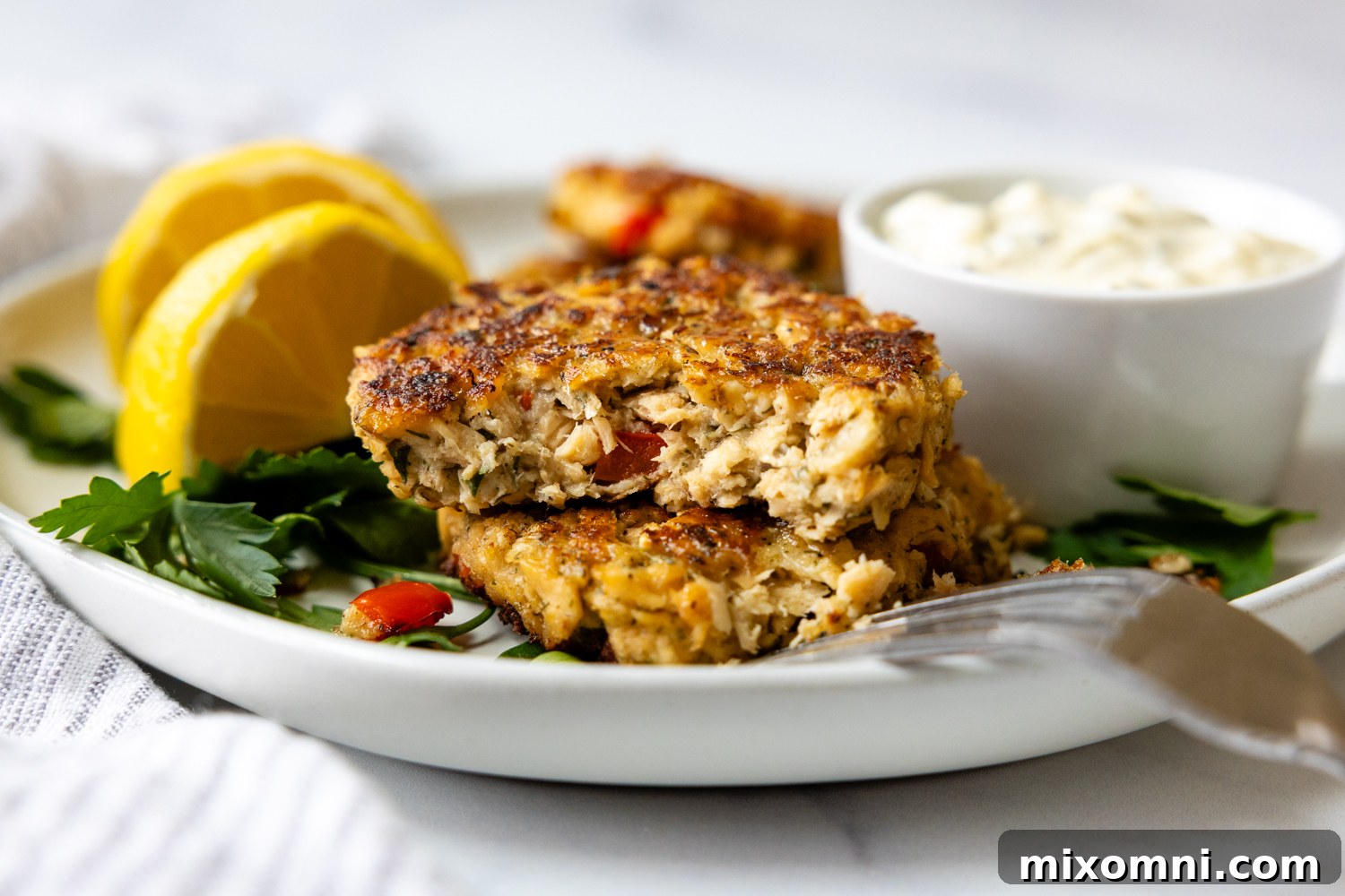 Two salmon patties stacked and cut open, revealing the tender, flaky texture of the patty.