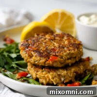 Gluten free salmon patties stacked on top of one another on a white plate.