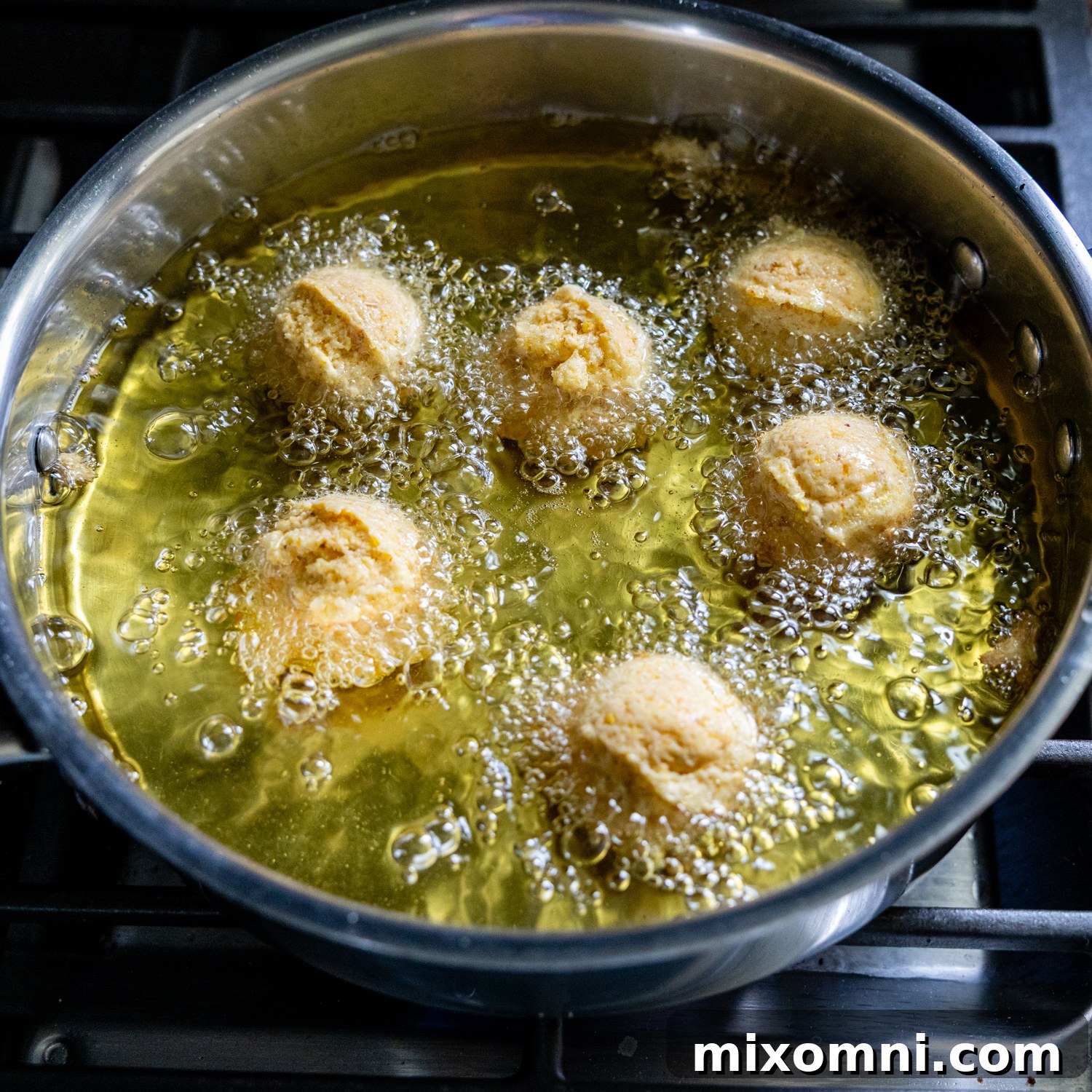 Hush puppies added to the oil for frying.