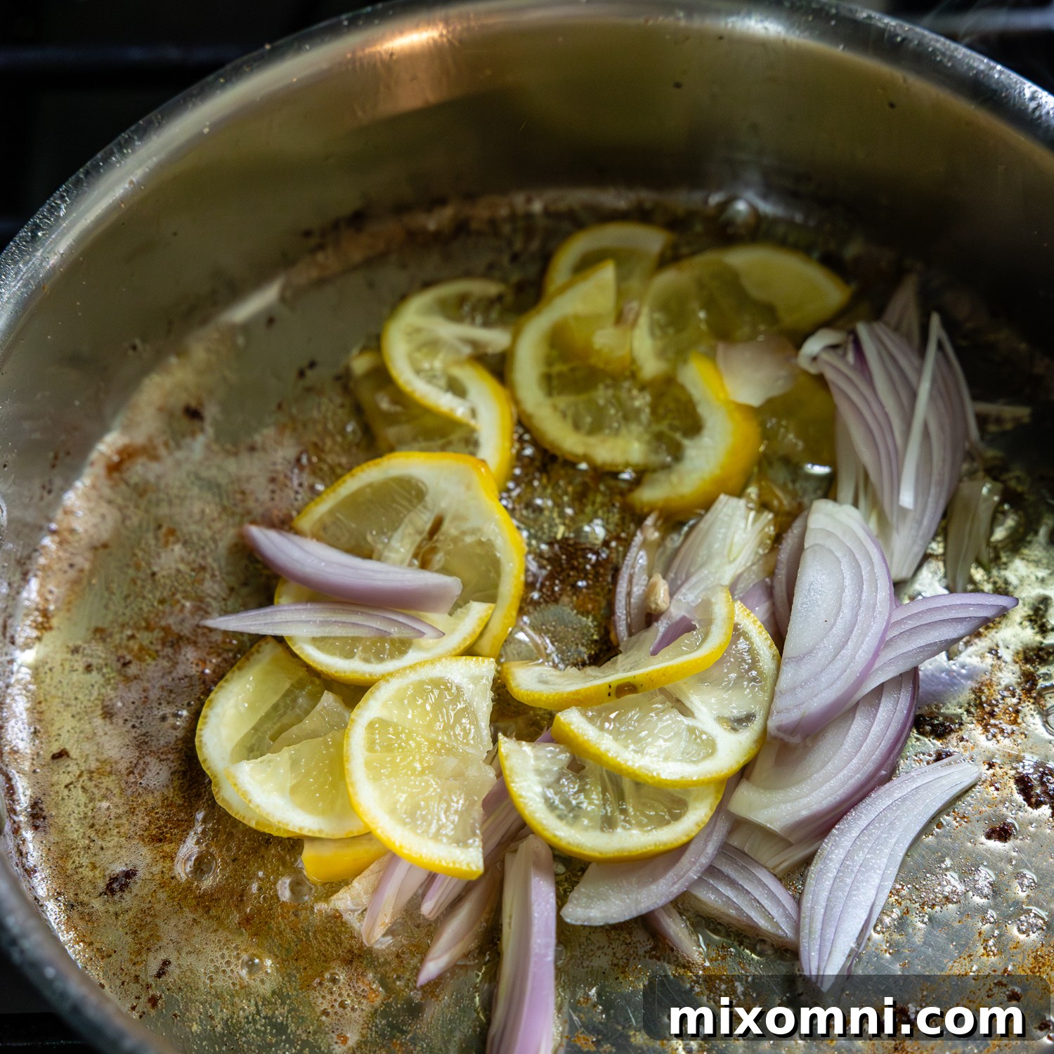 Lemon slices and shallots being sautéed.